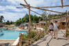 Espace aquatique La Baie au Camping Au Bois des Biches, avec grands bassins extérieurs, toboggans et espace détente ensoleillé.