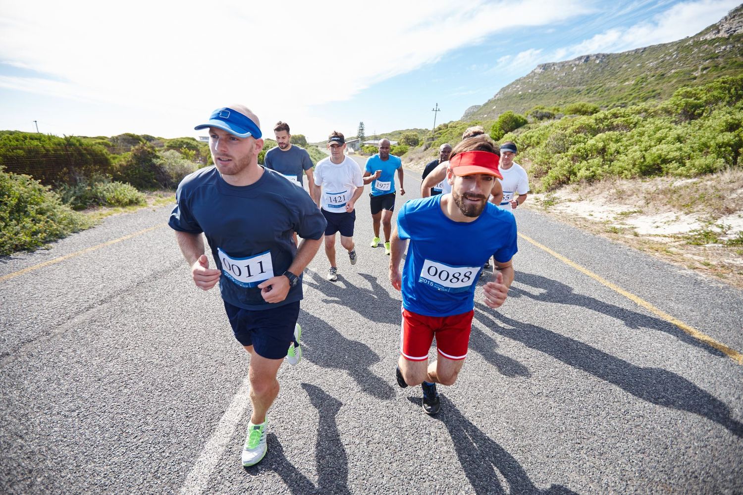 Coureurs avec dossards sur une route côtière lors d'une course sur route